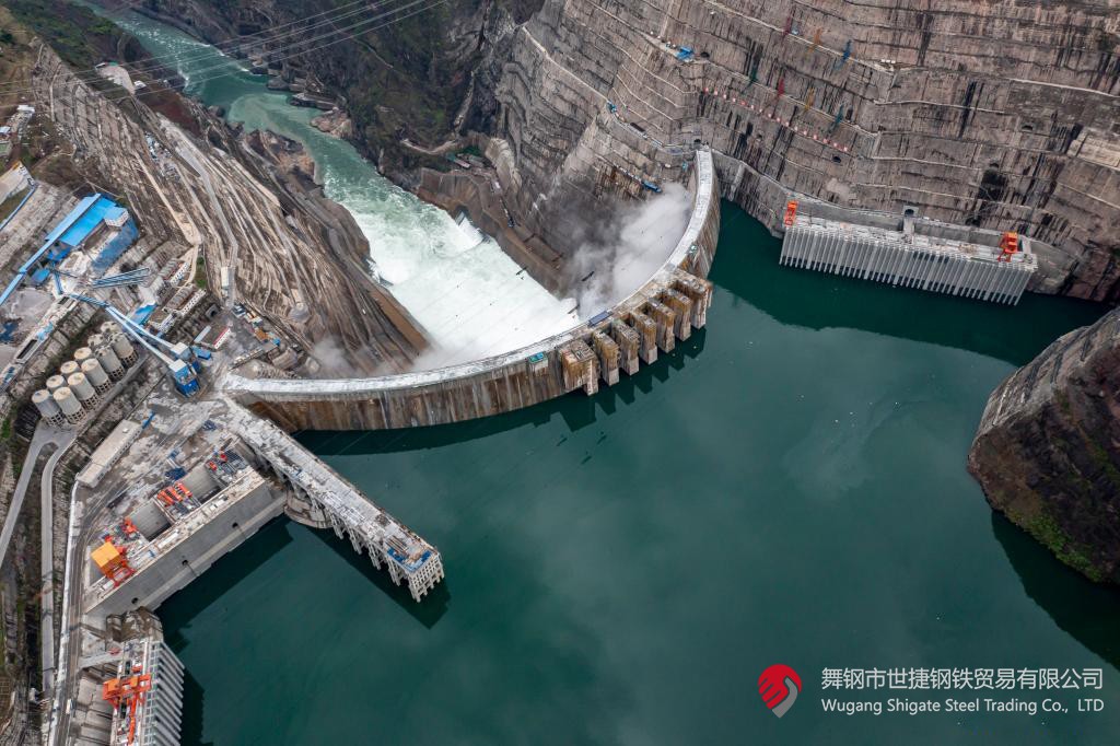 10月24日下午，白鶴灘水電站右岸地下廠房最后一倉封頂混凝土澆筑完成，標志著世界在建最大水電站地下廠房全線封頂。在該工程建設中，河鋼集團舞鋼公司累計生產供應Q500、Q345C/B、SX780等數(shù)個新品種鋼板4500噸，主要用于水電站水輪機座環(huán)、發(fā)電機頂蓋、控制環(huán)、壓力鋼管制造，大大加速了大型發(fā)電機組用鋼國產化進程。    據(jù)介紹，白鶴灘水電站位于四川省涼山州和云南省昭通市交界處，是世界在建規(guī)模最大的水電工程，裝機總容量1600萬千瓦，其左右岸地下廠房內分別布置8臺具有完全自主知識產權的單機容量達100萬千瓦的水輪發(fā)電機組，單機容量位居世界第一。10月24日下午，白鶴灘水電站成功蓄水至825米高程，首次達到正常水位，大壩將接受高水位全面檢驗。    該工程的規(guī)模天然決定了其施工難度極高，復雜的地形地質條件和技術指標等因素也給施工帶來了巨大挑戰(zhàn)。因此在電站建設材料及關鍵部位用鋼的選擇上，客戶慎之又慎，對焊接性能、韌性、強度等均有著極為嚴苛的技術要求。舞鋼公司憑借強大的質量品牌優(yōu)勢和雄厚的技術實力成功中標——數(shù)百噸“舞鋼牌”高技術含量的大厚度高級別水電鋼板用于制造世界單機容量最大的巨型水輪發(fā)電機組的座環(huán)。    隨后，舞鋼公司為白鶴灘水電站定制研發(fā)265mm厚的SXQ500D-Z35鋼板，并進一步制作加工件。公司科技部高強鋼研究所針對該鋼的生產重點和難點，提前制定措施，并在冶煉、制坯等關鍵環(huán)節(jié)派人進行跟蹤、協(xié)調。在科技、設備、生產人員的共同努力下，該批鋼板最終順利生產完畢。鋼板及試樣經公司、客戶和第三方檢驗機構檢驗合格后，在三和盛機建公司完成切割深加工。    交付客戶后，該鋼憑著焊接性能好、力學結構良好、低溫沖擊韌性強等優(yōu)點，承受住了巨大的水壓力和沖擊負荷，再次贏得設備制造方的高度評價。（舞鋼市委宣傳部 楊德坤 張培軍）